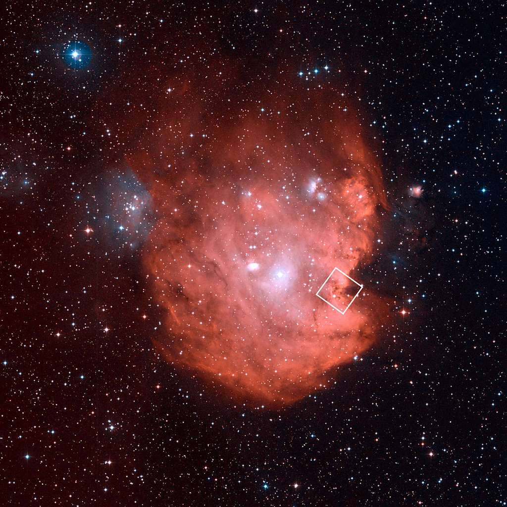 Évoquant dans son ensemble la tête d’un singe, la pâle nébuleuse NGC 2714, découverte en 1877 par le directeur de l’observatoire de Marseille Jean-Marie Édouard Stéphan, est ici photographiée par un télescope terrestre installé au sommet du mont Palomar (Californie) dans le cadre du sondage du ciel profond DSS2 (Digitized Sky Survey 2). Le carré bordé de blanc indique la région imagée dans l’infrarouge par Hubble. © Nasa, Esa, DSS, STScI, Aura, Palomar, Caltech